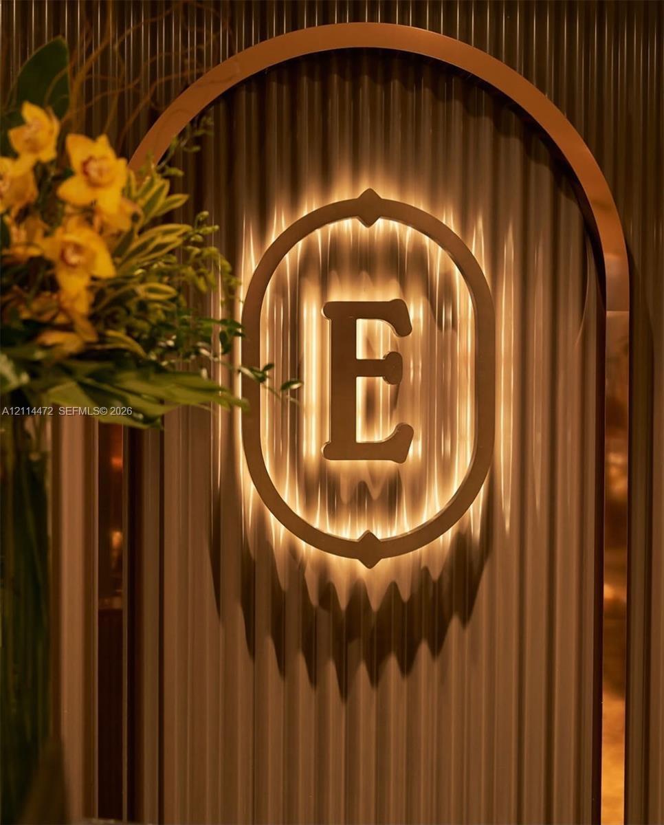 Arched entryway featuring ribbed wall paneling and a custom backlit metal insignia
