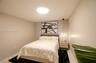 Neutral-toned room featuring a central flush-mount ceiling light and a suspended glass globe pendant light