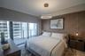 Floor-to-ceiling windows with roller shades, accent wall with textural finish, circular LED pendant lighting, and dual suspended bedside fixtures