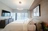 Floor-to-ceiling windows with roller shades, recessed cove lighting, circular LED chandelier, and textured wall finish