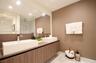Floating vanity with wood-finish cabinetry, dual rectangular vessel sinks, polished chrome faucets, and an expansive wall-to-wall mirror
