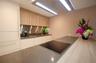 Kitchen featuring flat-panel cabinetry, stone countertops, metallic backsplash, integrated induction cooktop, and flush-mount overhead ventilation