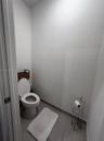 Neutral-toned ceramic tile flooring and a standard-height porcelain commode