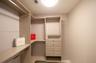Custom storage system featuring wood-finish shelving, integrated hanging rods, and a four-drawer cabinetry unit with hardware
