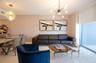 Interior space featuring floor-to-ceiling glass paneling, a multi-arm sputnik-style chandelier, a geometric tiered pendant light, and neutral wall tex