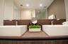 Dual rectangular vessel sinks atop a wood-finish vanity with a matching backsplash, polished chrome faucets, and a large integrated mirror