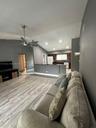 Vaulted ceilings, wood-finish flooring, recessed lighting, ceiling fan, and peninsula kitchen layout