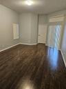 Wood-finish flooring, vaulted ceiling, sliding glass doors with transom window, and flush-mount ceiling lighting