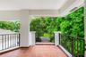 Covered terrace featuring terra cotta tile flooring, metal railing, and concrete pillars