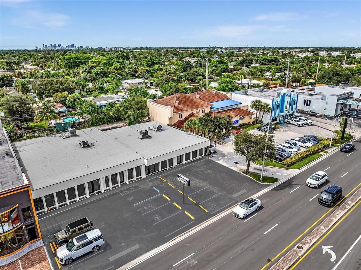 Commercial property featuring a flat-roof structure with glass-paneled storefronts and a dedicated asphalt parking lot with striped spaces