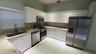 Kitchen featuring white cabinetry, stone-finish countertops, stainless steel appliances, a high-arc faucet, and large-format tile flooring