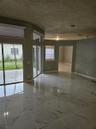 Large-format polished tile flooring, sliding glass doors, transom windows, and recessed ceiling lighting