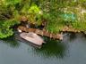 Private wooden dock featuring a fixed pier, integrated ladder, and a modular floating boat lift