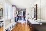 Custom dressing room featuring integrated floor-to-ceiling cabinetry, recessed lighting, wood-finish flooring, plantation shutters, and a built-in van