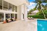 Covered patio featuring floor-to-ceiling glass paneling, stone-tile flooring, and a swimming pool