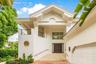 Architectural exterior featuring a vaulted gabled roofline, decorative corbels, a private second-story balcony with metal railings, a circular accent 