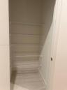 Storage space featuring five tiers of white wire shelving and tile flooring