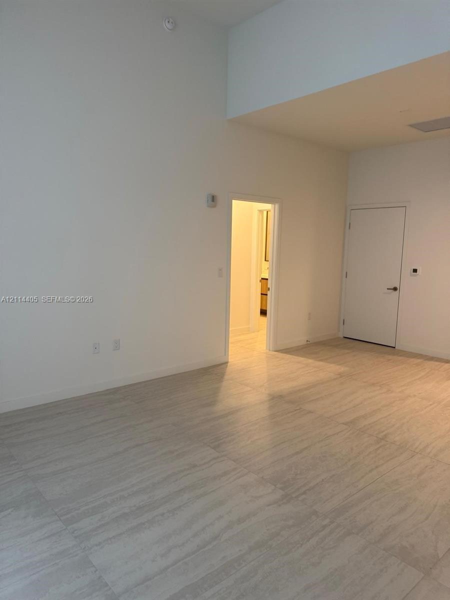 High-ceiling interior featuring large-format tile flooring and neutral wall finishes