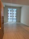 Floor-to-ceiling sliding glass doors, full-height wood-finish cabinetry, and large-format tile flooring