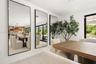 Full-length wall mirrors with thin black frames, recessed ceiling lighting, and large-format tile flooring