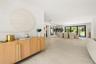Light-toned flooring, recessed lighting, and expansive black-framed sliding glass doors opening to the exterior