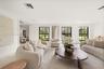Spacious living area featuring large format tile flooring, black-framed multi-pane windows, and recessed lighting
