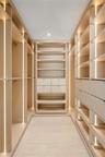 Custom walk-in closet featuring floor-to-ceiling built-in cabinetry, integrated vertical LED strip lighting, modular shelving, and multi-drawer storag