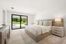 Spacious room featuring floor-to-ceiling sliding glass doors, neutral tile flooring, and recessed lighting