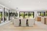 Open-concept interior featuring large-format tile flooring, recessed ceiling lighting, wall-to-wall mirrors, and multi-panel sliding glass doors openi