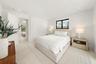 Bright room featuring recessed lighting, smooth-finish walls, wood-finish flooring, full-wall built-in cabinetry with flat-panel doors, and a black-fr