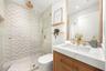 Bathroom for Room 2 and 3 featuring a walk-in shower with chevron-patterned tile, frameless glass enclosure, rainfall showerhead, wood-finish vanity w