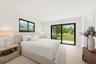 Suite Bedroom 1 ,Bright interior featuring neutral walls, large sliding glass doors, black-framed windows, and light-toned flooring