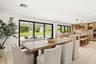 Open-concept kitchen and dining area featuring light wood-finish cabinetry, a large kitchen island with integrated seating, recessed lighting, and exp