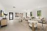 Open-concept living space featuring neutral wall-to-wall flooring, oversized windows with black frames, and recessed lighting