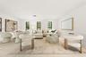 Living area featuring light-toned tile flooring, recessed lighting, and three tall windows with black frames