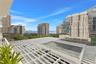 Private balcony featuring a structural white trellis overhead and a perspective of the surrounding urban skyline, waterfront, and marina
