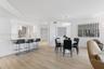 Open-concept space featuring light wood-finish flooring, recessed lighting, built-in kitchen cabinetry with integrated stainless steel appliances, and