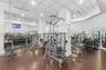 Fitness center featuring wood-finish flooring, recessed lighting, drop ceiling panels, and full-length wall mirrors