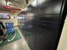 Secure metal parcel storage lockers featuring a matte black finish and integrated electronic kiosk interface