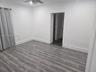 Interior space featuring wood-finish flooring, white walls, and a ceiling-mounted light fixture