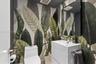 Botanical print wallcovering, white vanity cabinet with a rectangular basin, polished chrome faucet, and black-framed rectangular wall mirror