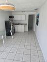 Kitchenette featuring white cabinetry, stone-finish countertops, ceramic tile flooring, and a pendant ceiling light fixture