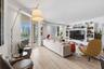Open-concept living space featuring wood-finish flooring, floor-to-ceiling sliding glass doors, a large white built-in media center with integrated sh