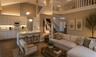 Vaulted ceilings with recessed lighting, kitchen featuring white shaker-style cabinetry, breakfast bar with stone-surfaced countertop, wood-finish flo