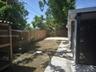 Outdoor area featuring wood-plank fencing, a concrete patio, and pavers