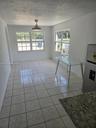 Neutral tile flooring, dual multi-pane windows, and a central ceiling fan