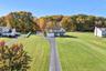 Two-story residence featuring a two-car attached garage, expansive lot, paved driveway, and detached storage shed