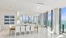 Open-concept living space featuring floor-to-ceiling windows, polished stone flooring, recessed lighting, and dual woven pendant light fixtures