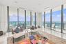 Floor-to-ceiling glass walls, expansive balcony, stone-finish flooring, recessed ceiling lighting, and horizontal ocean backdrop