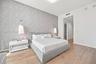 Textured gray accent wall featuring dual wall-mounted pendant lights and wide-plank wood-finish flooring